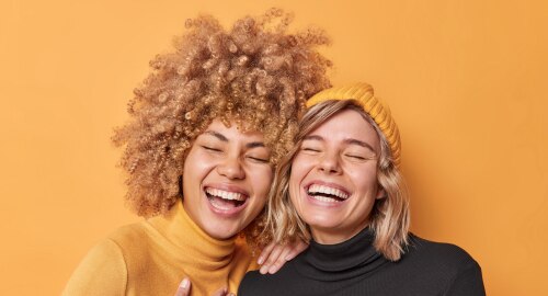 Two happy women one with curly hair and the other wavy