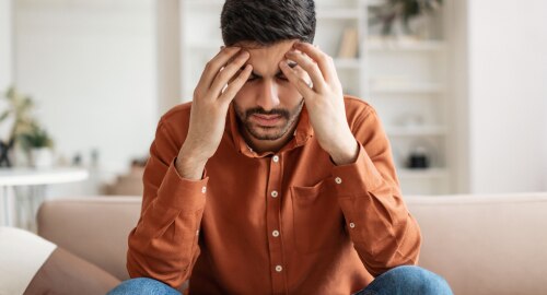 A  man with his head in his hands looking worried