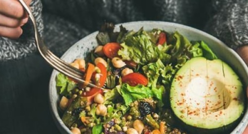 Bowl of vegan food including avocado and chickpeas