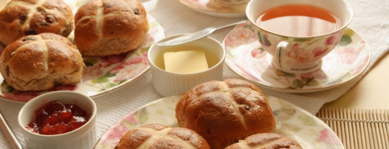 fresh hot cross buns with jam spread and tea