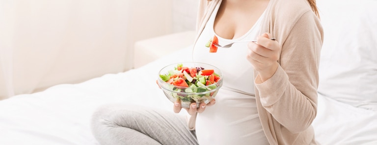 pregnant women eating colourful bowl of salad