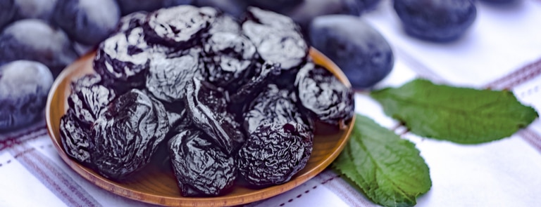 close up of prunes with plums in backgrround