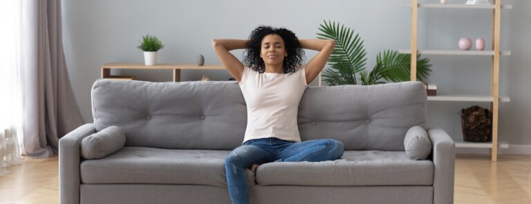 woman relaxing on sofa with closed eyes