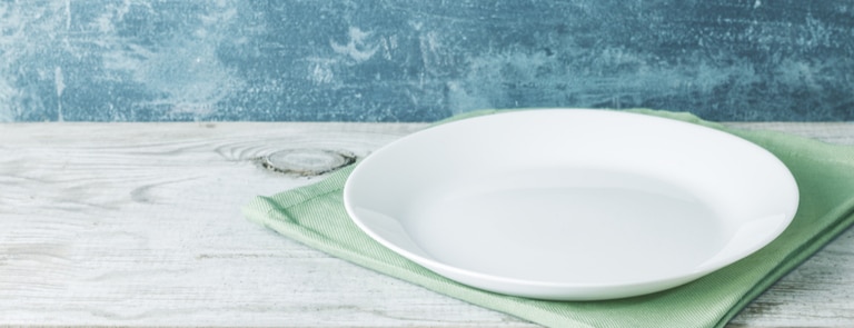 empty dinner plate on cloth and table