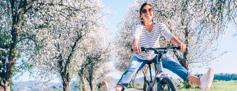 woman in a spring meadow riding a bicycle