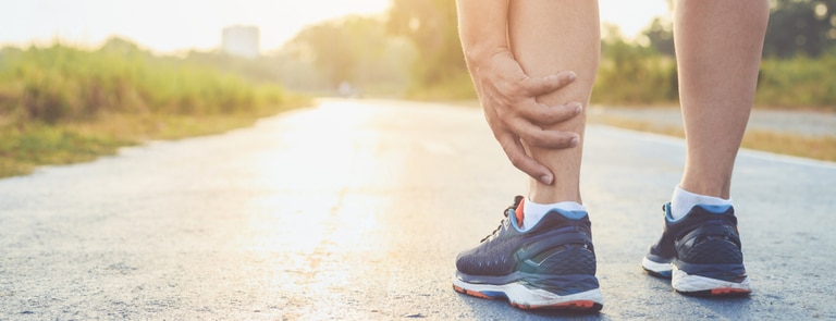 male runner stopped because of pain in leg tendon