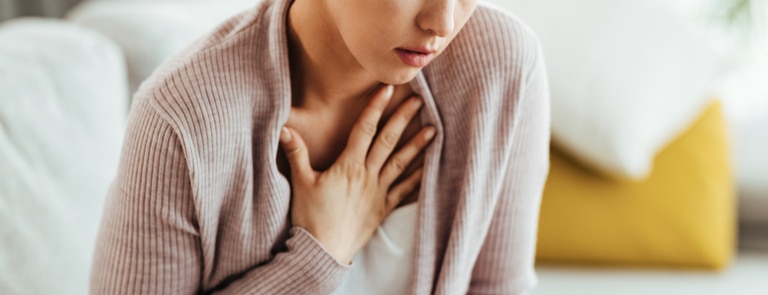 woman holding hand on chest in pain