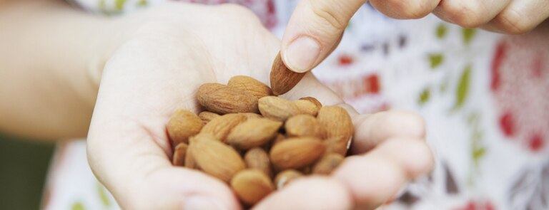 woman snacking on handful of almonds