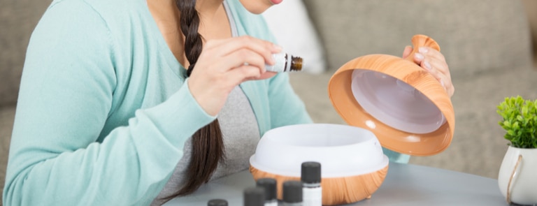 woman using essential oil diffuser