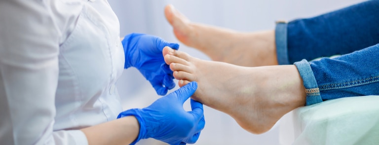 medical professional inspecting patient's toes