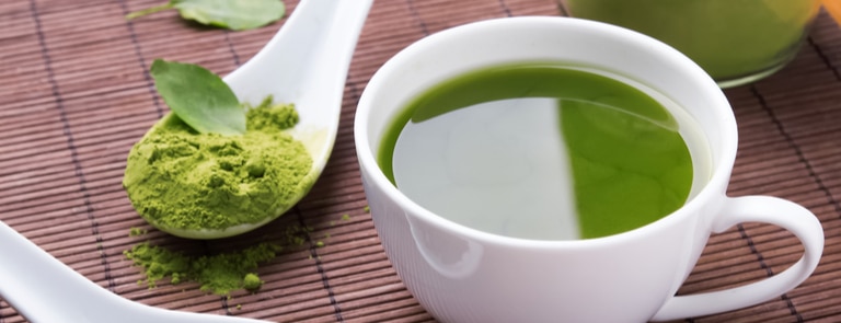 close up of green tea with spoon of powder
