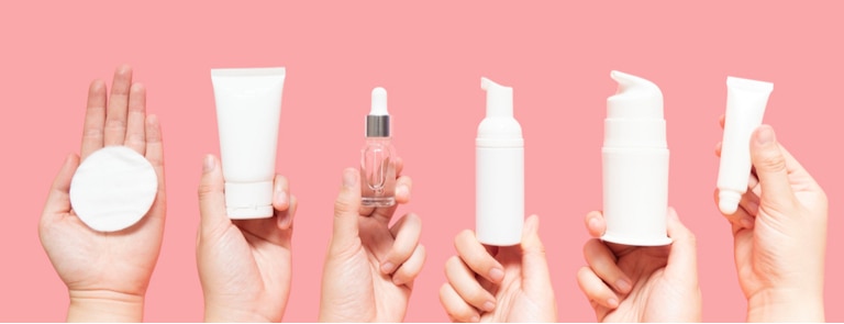female hands holding up various beauty products