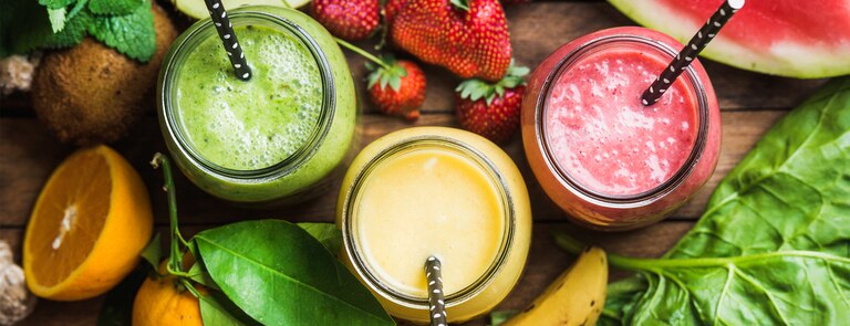 selection of fruit smoothies with fresh cut fruit