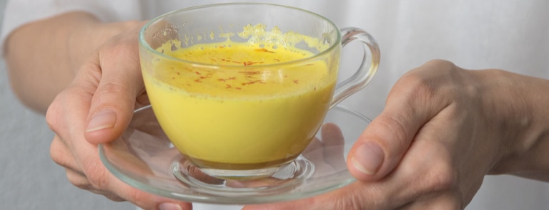 holding a cup of golden milk