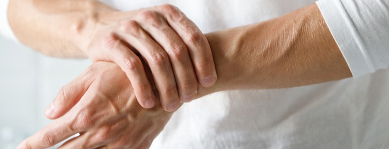 person with arthritis holding their wrist 