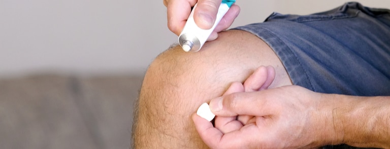 person applying cream to their knee