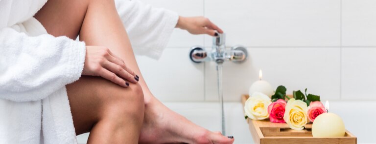 women running a bath with candles and natural scents