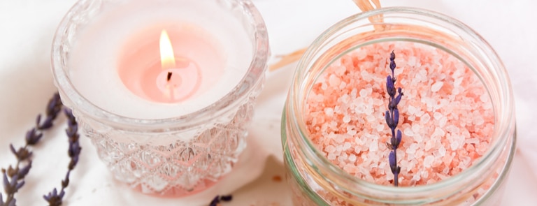 bowl of himalayan pink salt next to candle