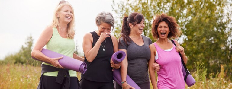 group of mature menopausal women going to a yoga class together