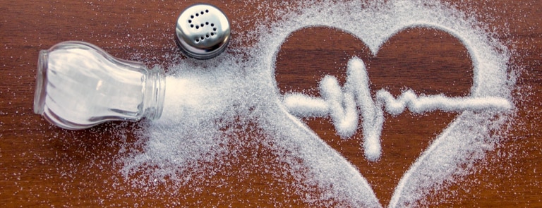 salt pouring onto a wooden surface into the shape of a heart
