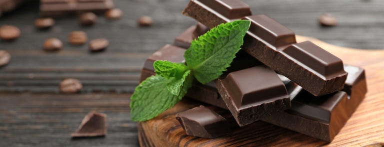 pieces of dark chocolate on a board with mint 