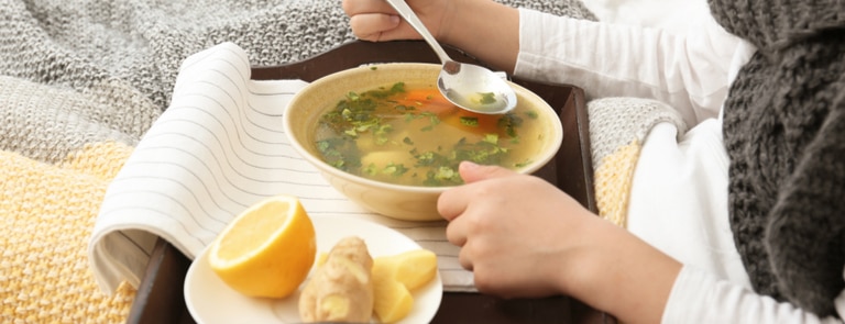 sick person eating warm soup after being sick 