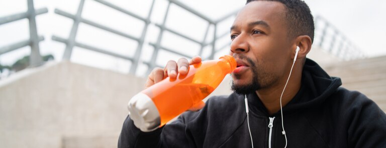 runner drinking energy drink with electrolytes in it after exercise