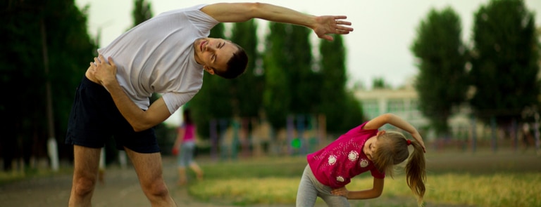 a man and girl practicing their stretching 