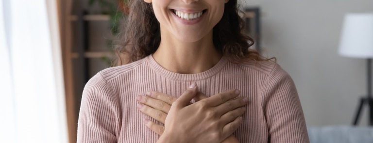 woman holding her chest and showing gratitude