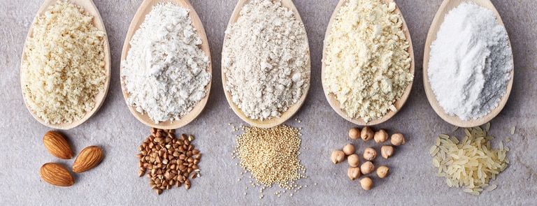 different kinds of gluten free flour in wooden spoons 