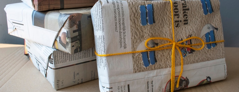 christmas presents wrapped in newspaper and twine for sustainable gifting
