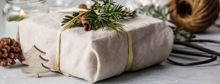 christmas present wrapped in fabric and cloth ribbon for sustainable gifting