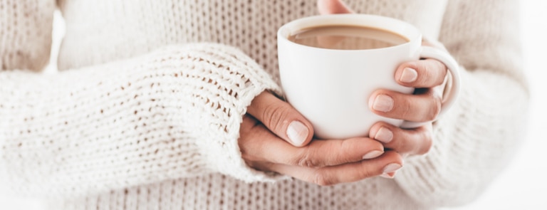 cold hands holding warm cup of tea