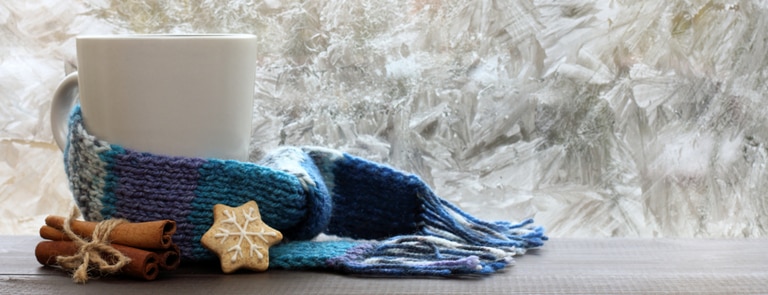 warm cup of tea with scarf next to it 