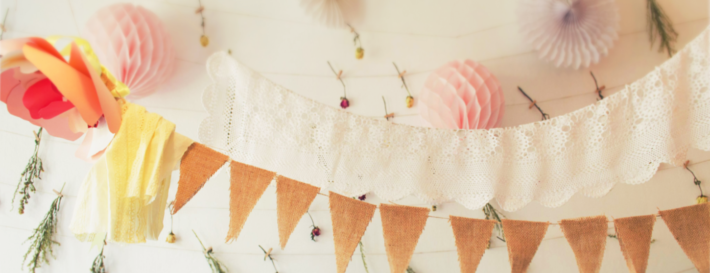 hanging paper decorations on wall with cloth bunting to decorate party in eco friendly sustainable way