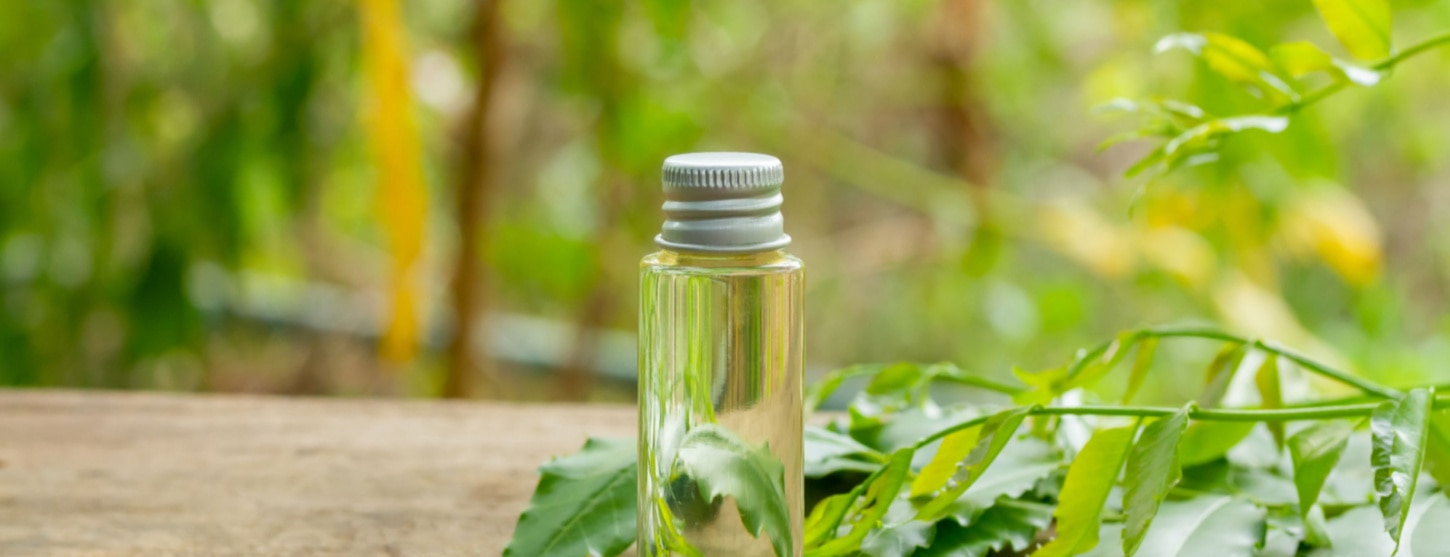 bottle of neem oil for hair and skin on wooden table 