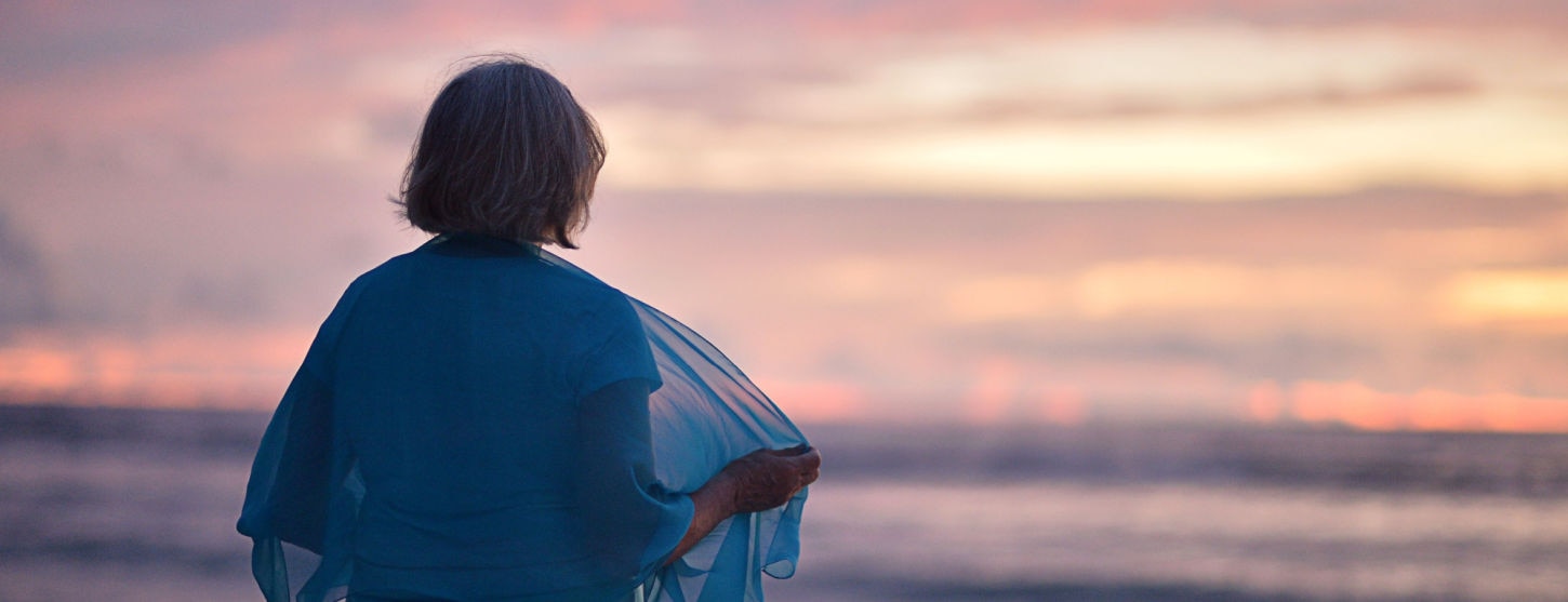 Elderly lady facing the sea