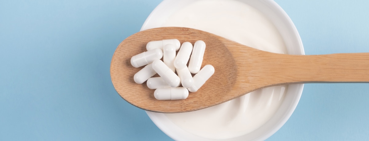probiotic capsules on a bowl of live yoghurt