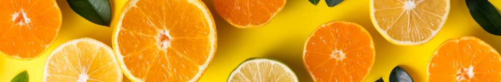 oranges and vitamin c capsules on a yellow background