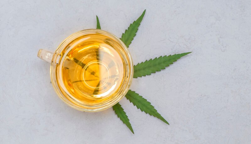 CBD tea in glass cup with leaf