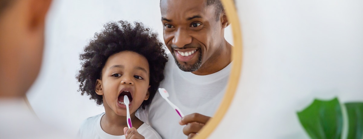 father and son in the mirror brushing teeth