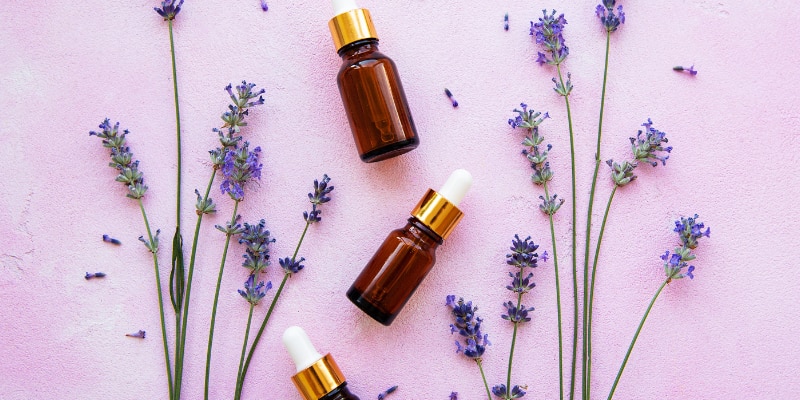 lavender oil on a purple background with leaves
