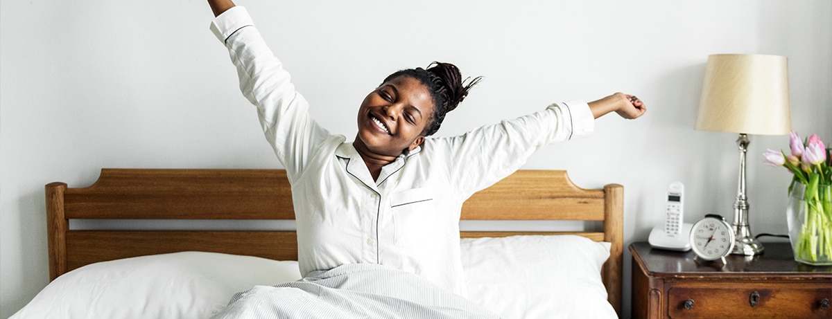 A lady waking up in her bed, looking happy and stress free