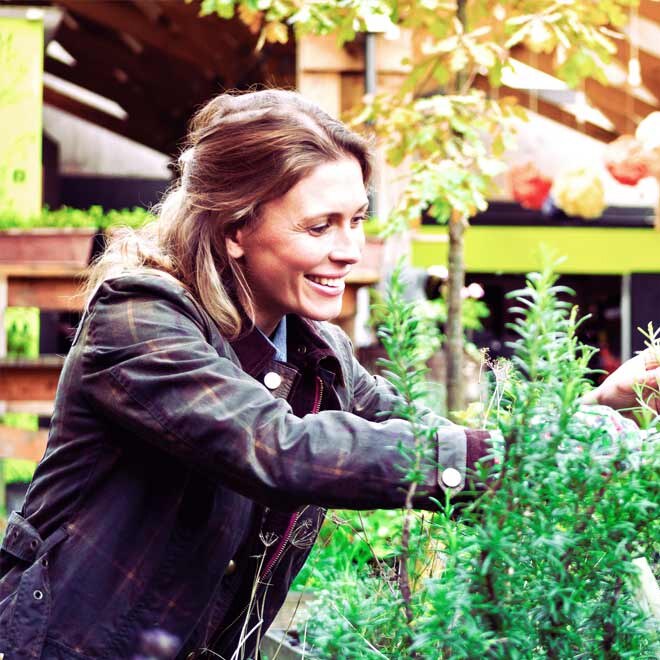 A photo of a smiling lady gardening