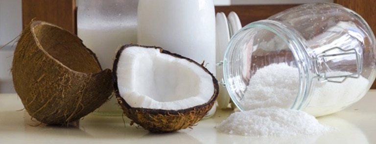 A split coconut, coconut milk, coconut powder, and coconut kefir