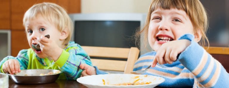 Two Children Eating And Smiling