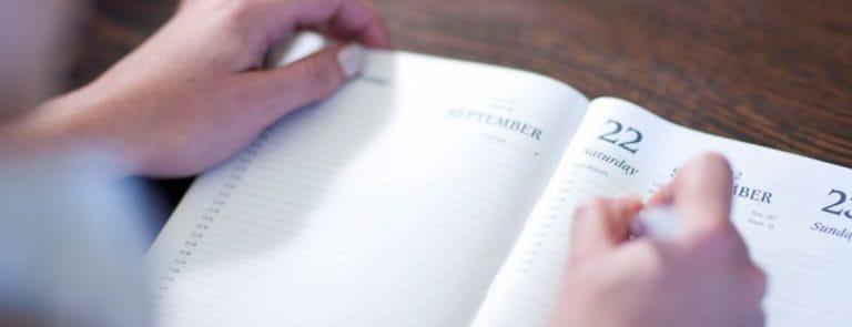A Person writing in a Calendar