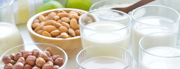 Glasses of Milk next to Almonds and other Nuts