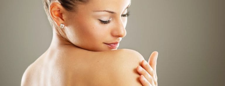A women rubbing the skin on her shoulder - skin facts