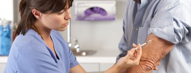 A Doctor or Nurse injecting a patients arm